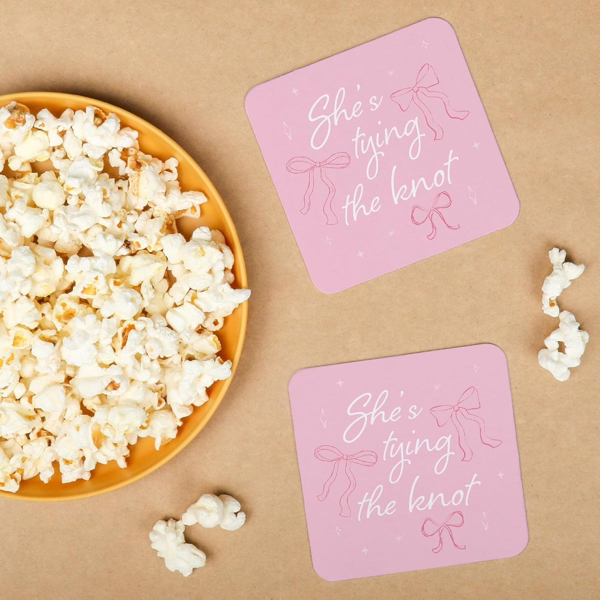 25 Ct She's Tying The Knot Drink Coasters, 4-Inch Disposable Square Paper Coasters for Pink Bows Bridal and Bachelorette Party, Funny Cocktail Table Decor for Bar Drinks